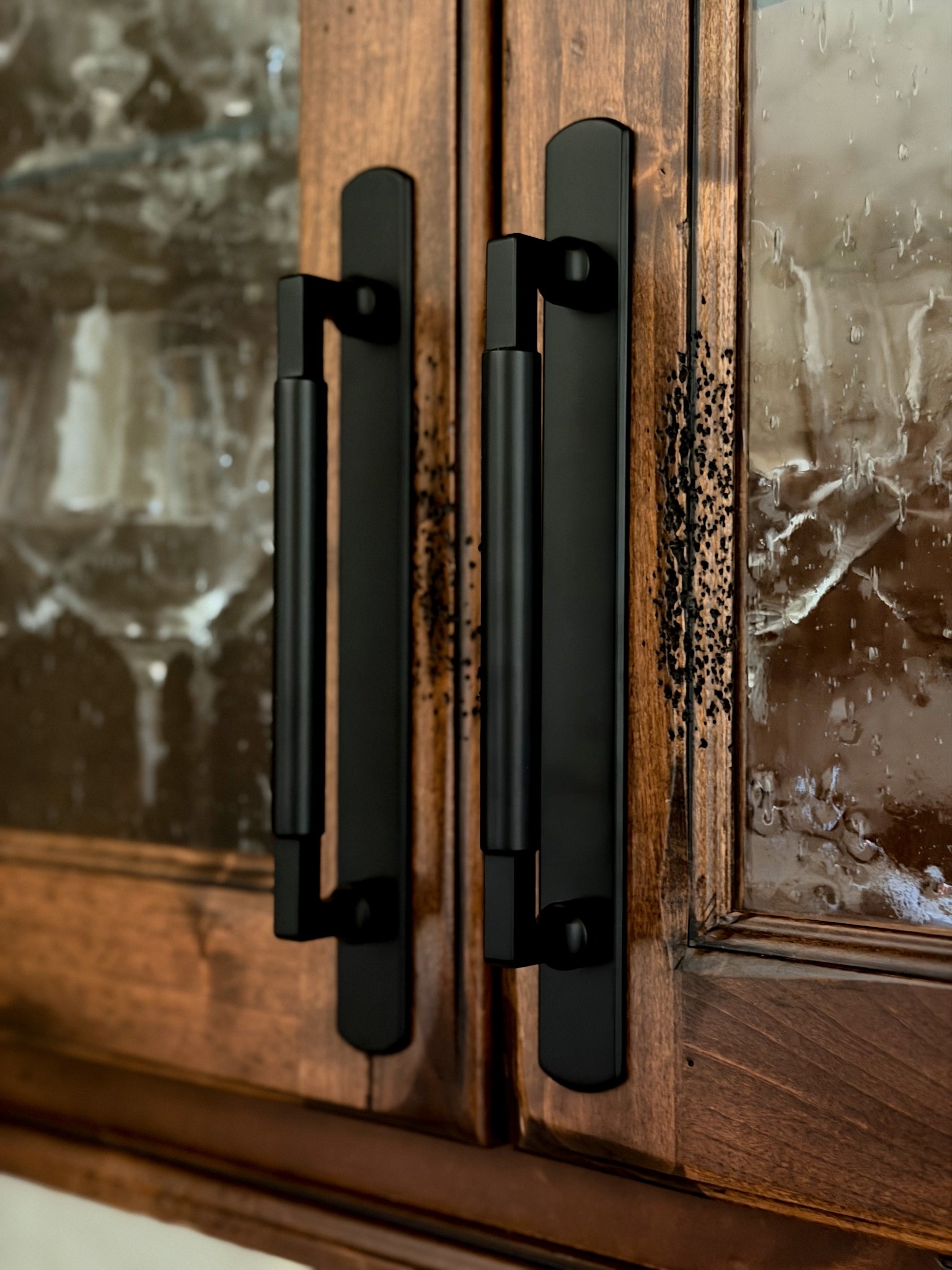 black cabinet pulls on rustic wood glass front cabinets in littleton co kitchen remodel