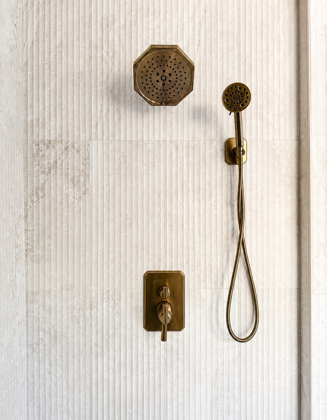 brass rain shower and handheld shower fixtures on fluted tile in littleton co kitchen and bathroom remodel