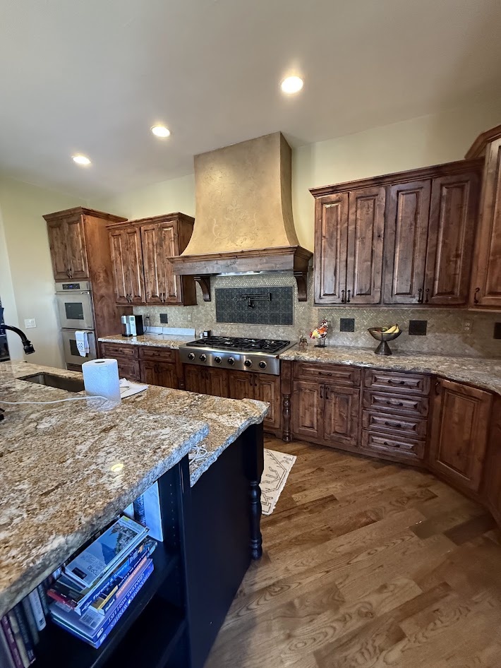 littleton co kitchen and bathroom remodel before kitchen with rustic wood cabinetry custom range hood and granite island