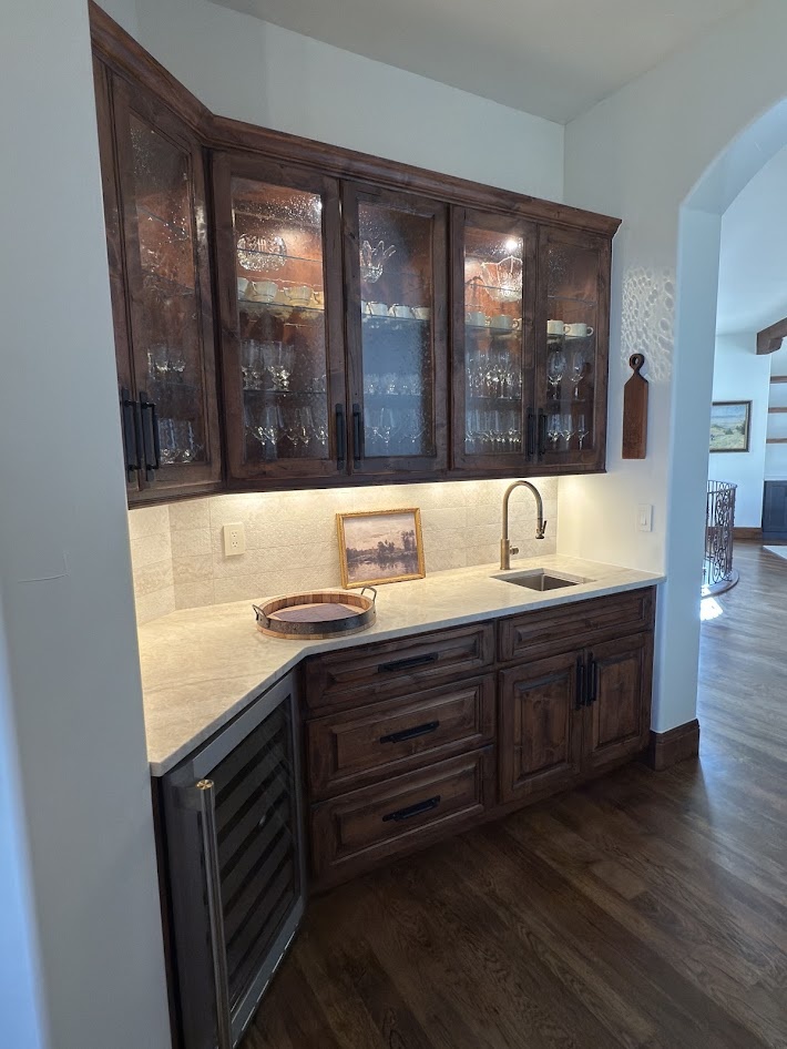 littleton co kitchen and bathroom remodel before wet bar with glass front wood cabinets sink and beverage refrigerator