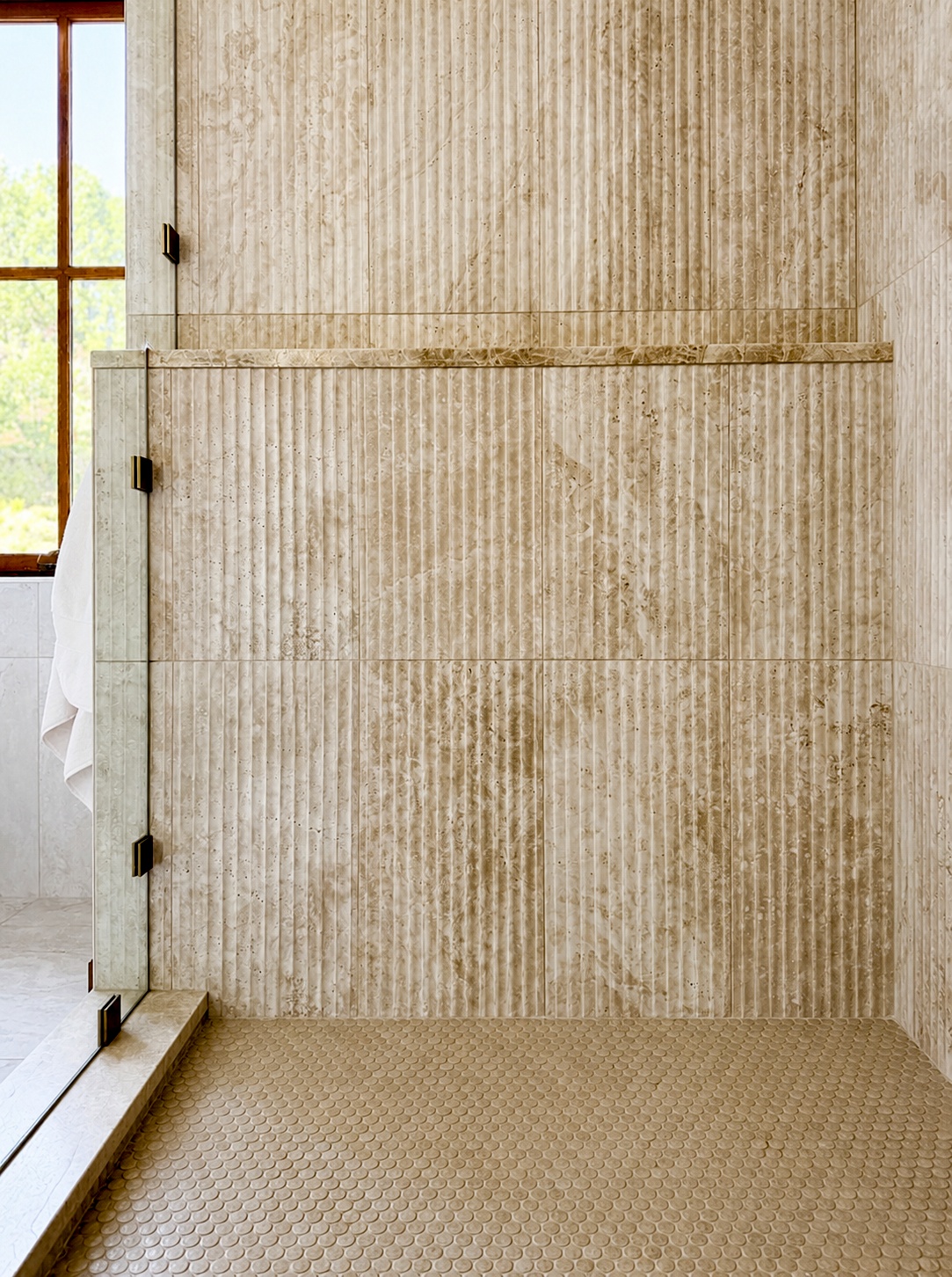 walk in shower with textured stone tile and glass panel in littleton co bathroom remodel