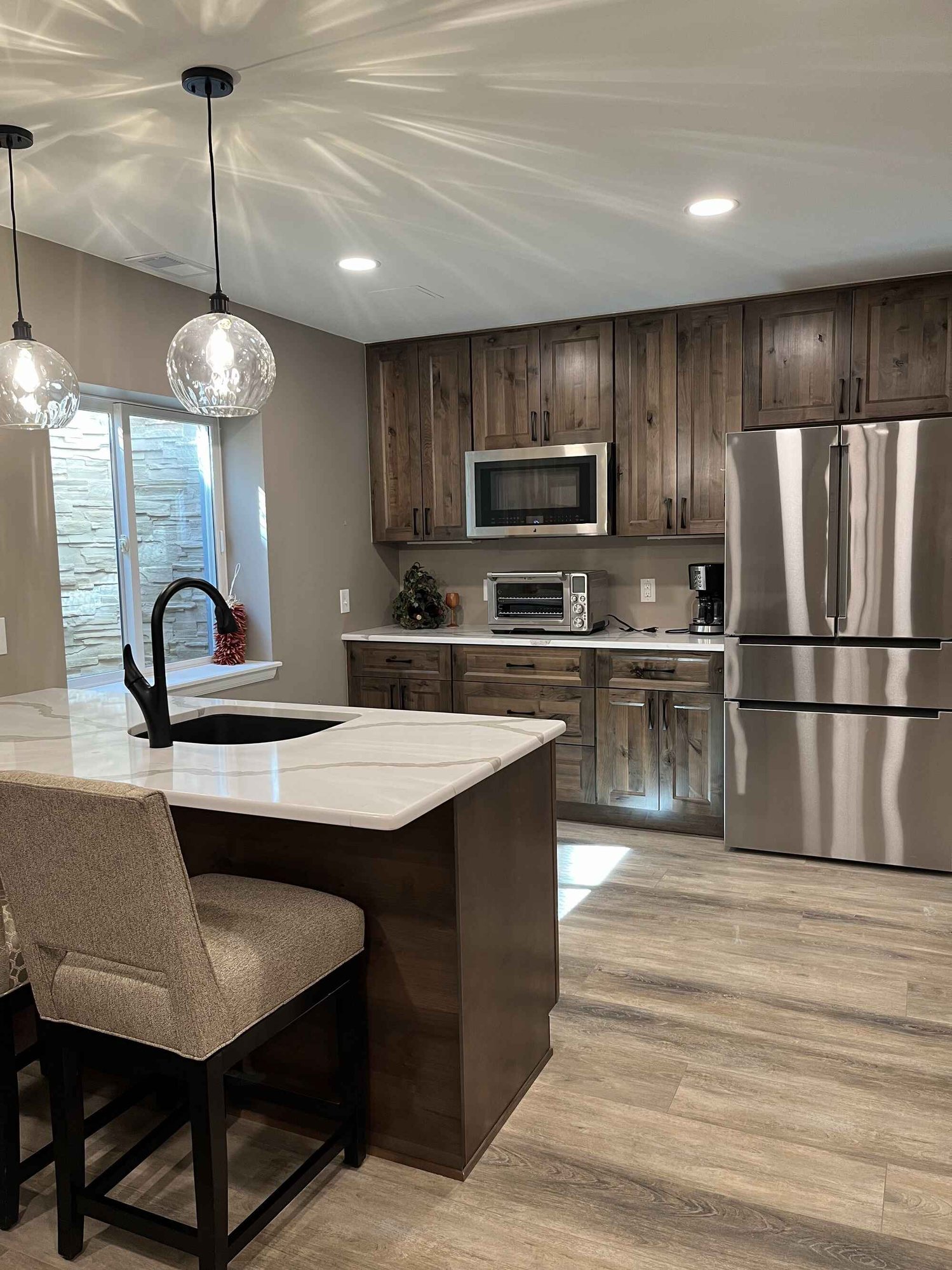 Beautiful-open-basement-kitchen-brown-cabinets-quartz-countertops-Littleton-Colorado3