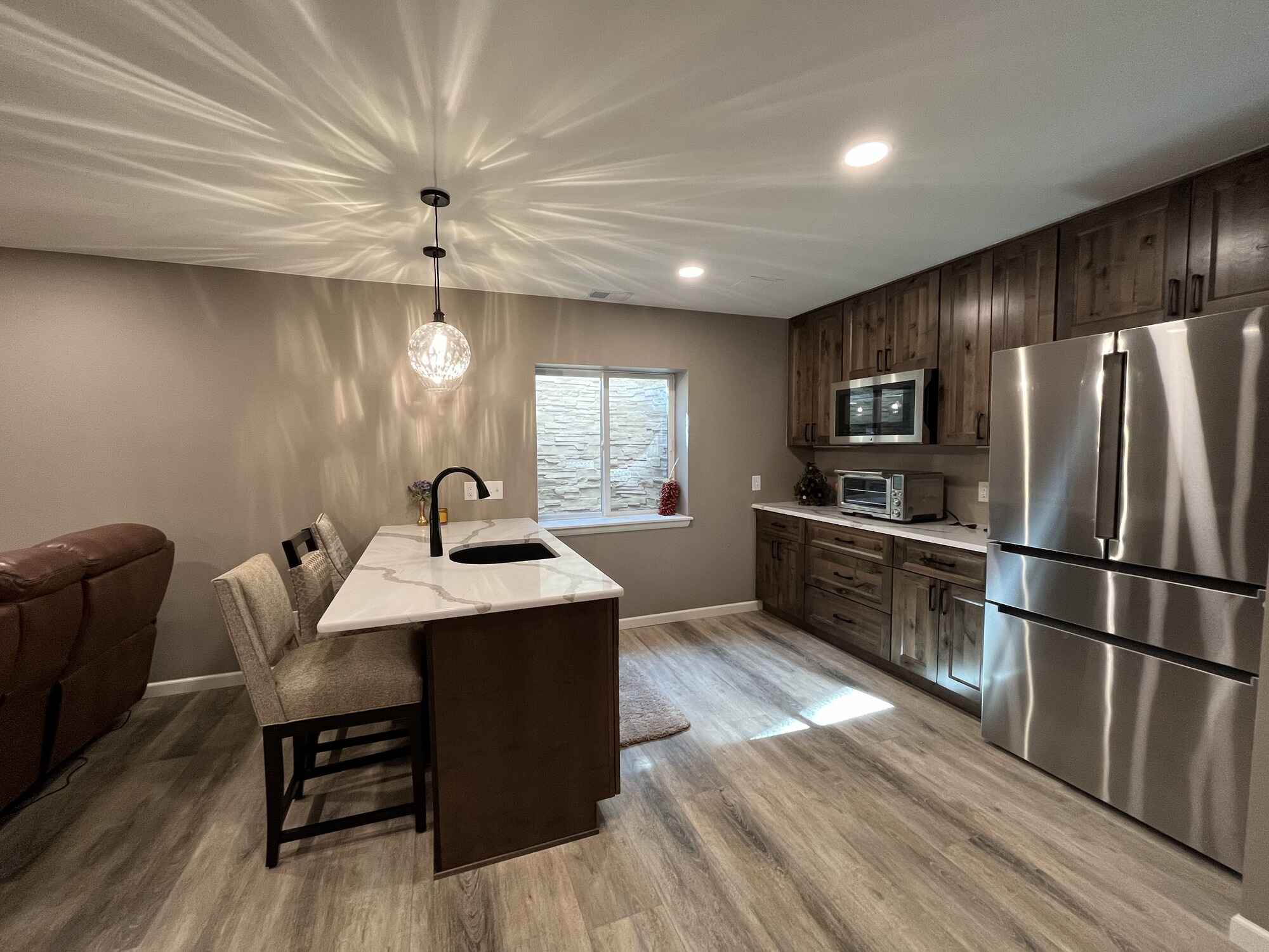 Beautiful-open-basement-kitchen-brown-cabinets-quartz-countertops-Littleton-Colorado6