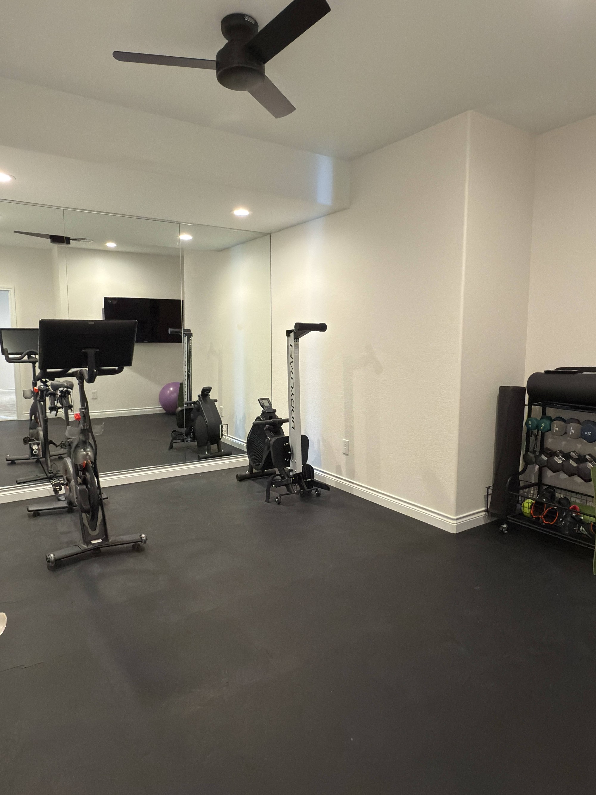 after basement remodel fitness room with cardio equipment and rubber flooring in littleton