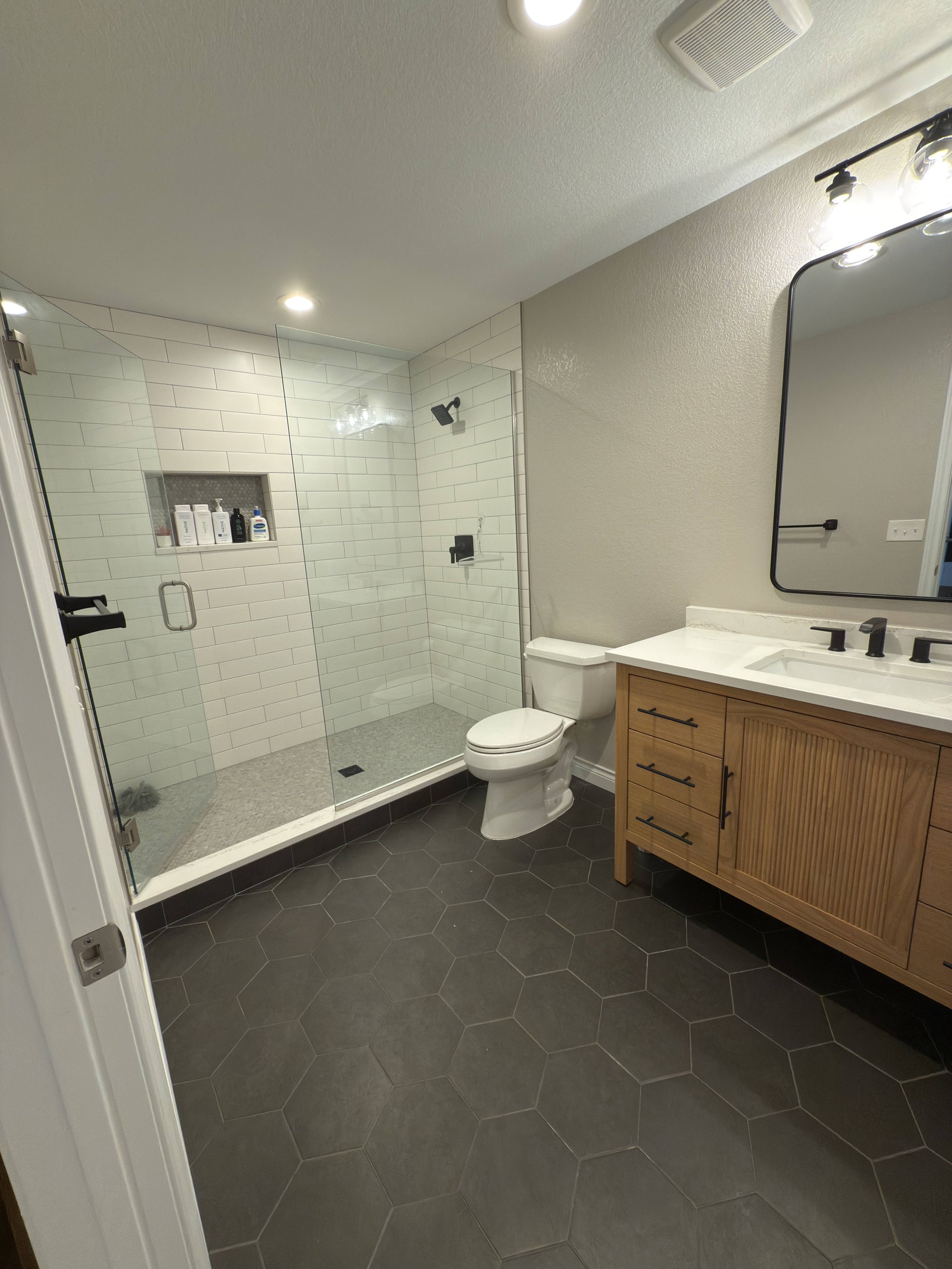 after basement remodel wet bar with dark cabinets and wine refrigerator in littleton