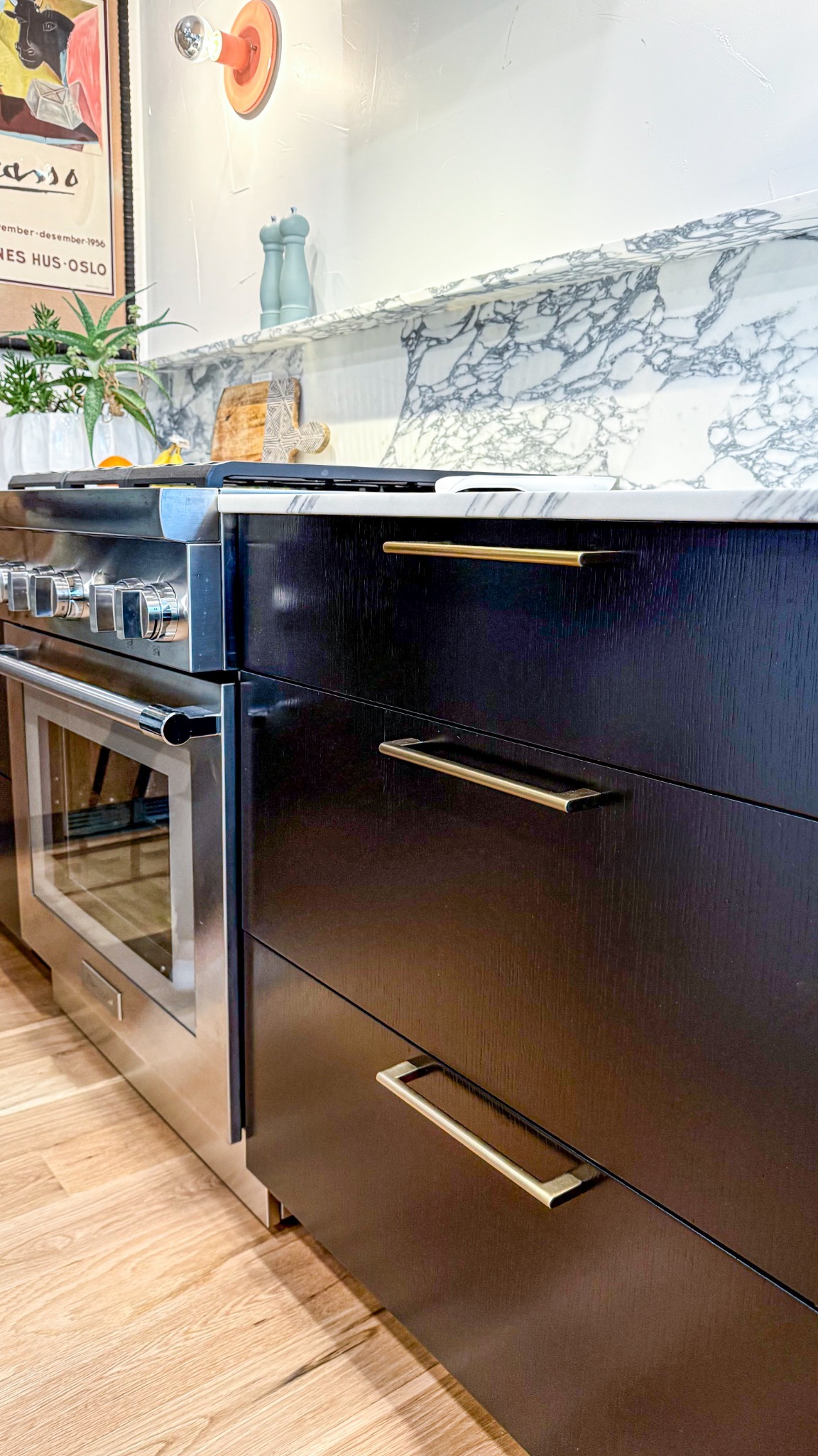 after-kitchen-remodel-with-black-lower-cabinets-and-marble-backsplash-in-castle-pines