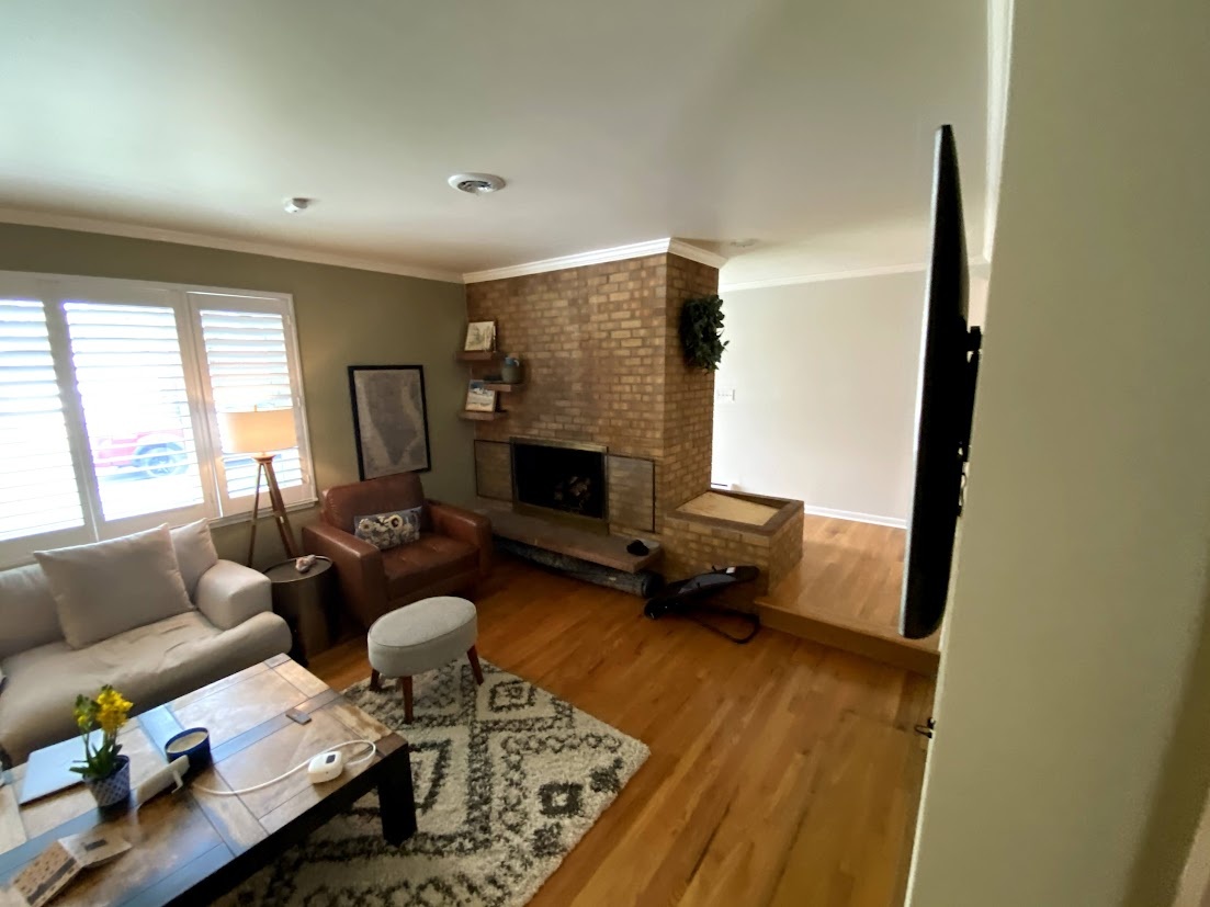 before-littleton-whole-home-remodel-living-room-with-brick-fireplace-and-hardwood-flooring