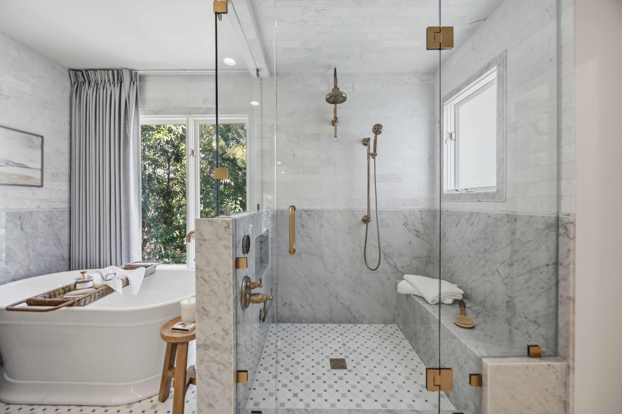 Luxury primary bathroom remodel featuring a spacious glass-enclosed walk-in shower, marble tile, brass fixtures, and freestanding soaking tub in Greenwood Village, CO Luxury primary bathroom remodel featuring a spacious glass-enclosed walk-in shower, marble tile, brass fixtures, and freestanding soaking tub in Greenwood Village, CO