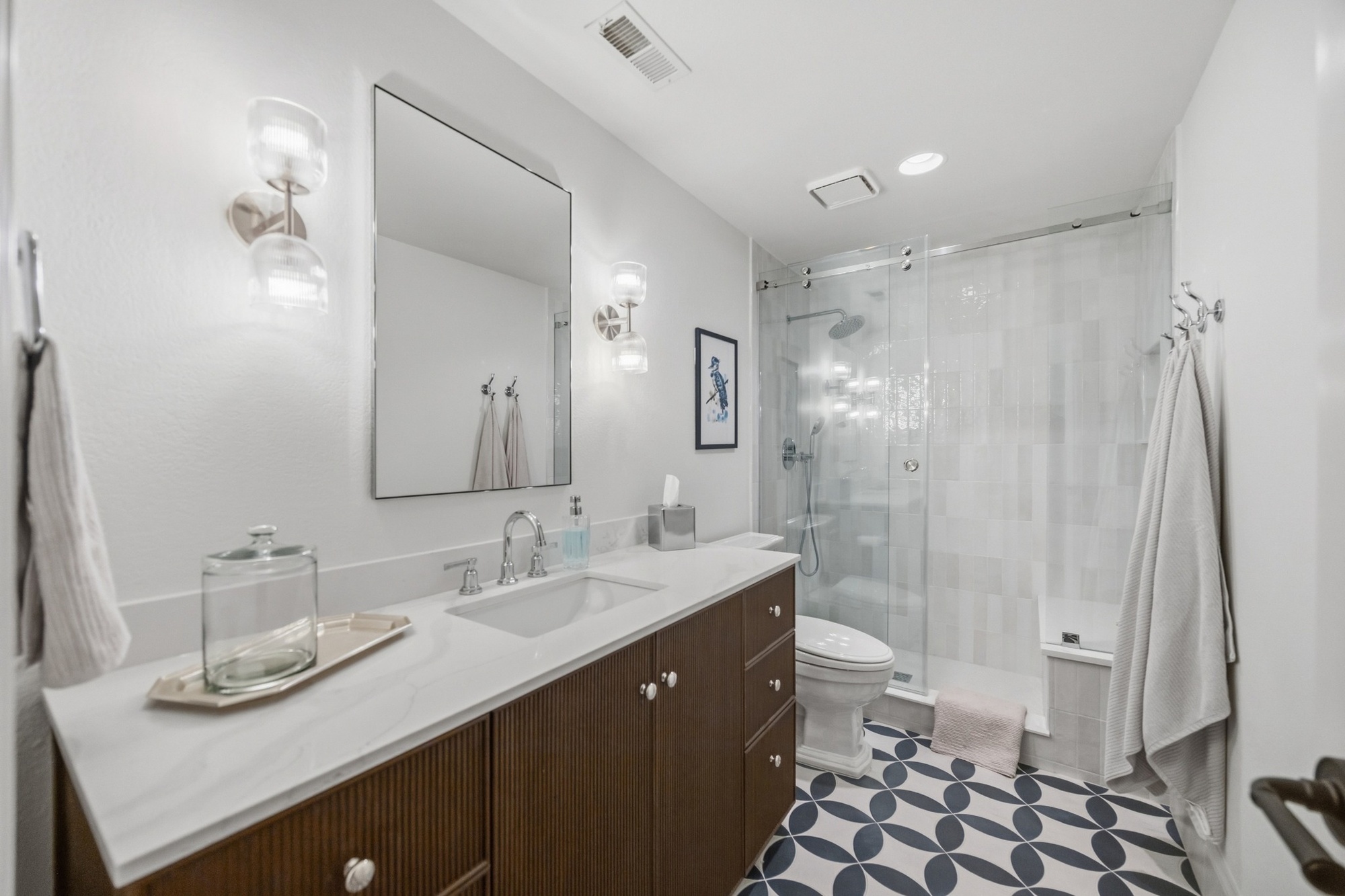 bathroom with long wood vanity glass shower and patterned tile floor in greenwood village co whole home remodel