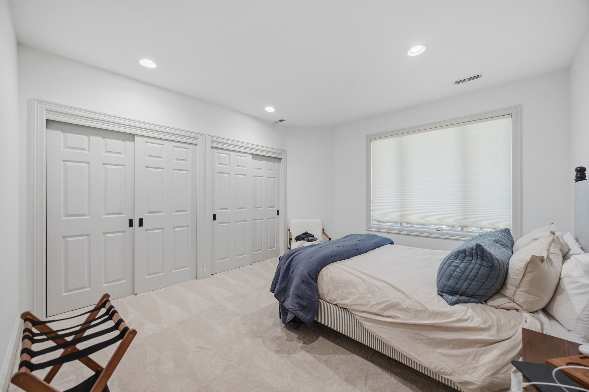 bedroom with white closets neutral carpet and blue bedding in greenwood village co whole home remodel