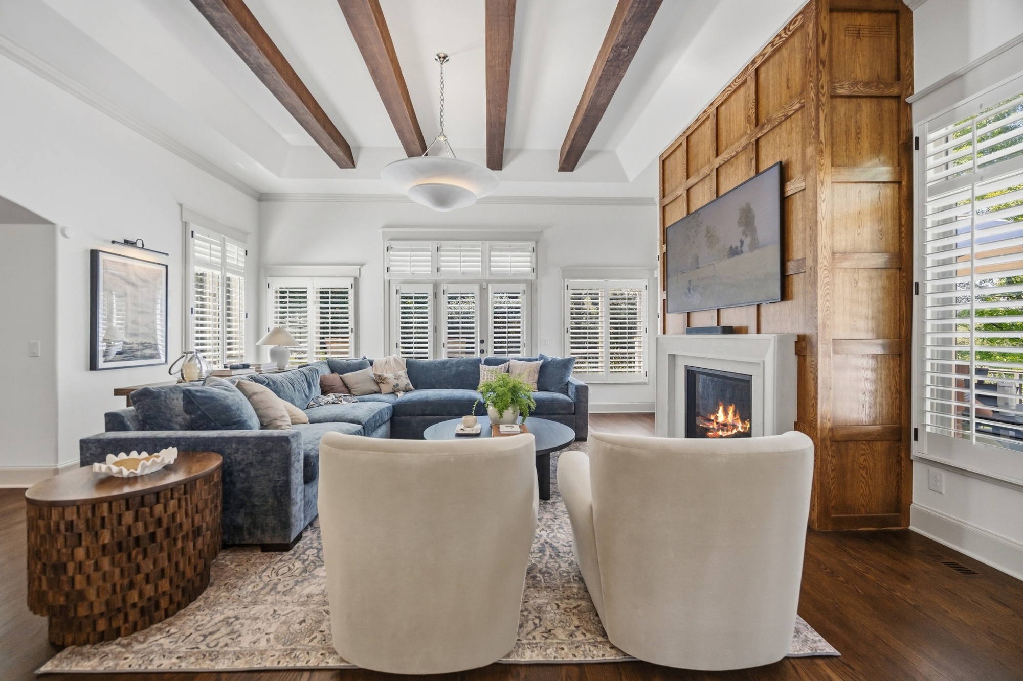 bright living room with wood paneled fireplace wall and exposed beams in greenwood village co whole home remodel