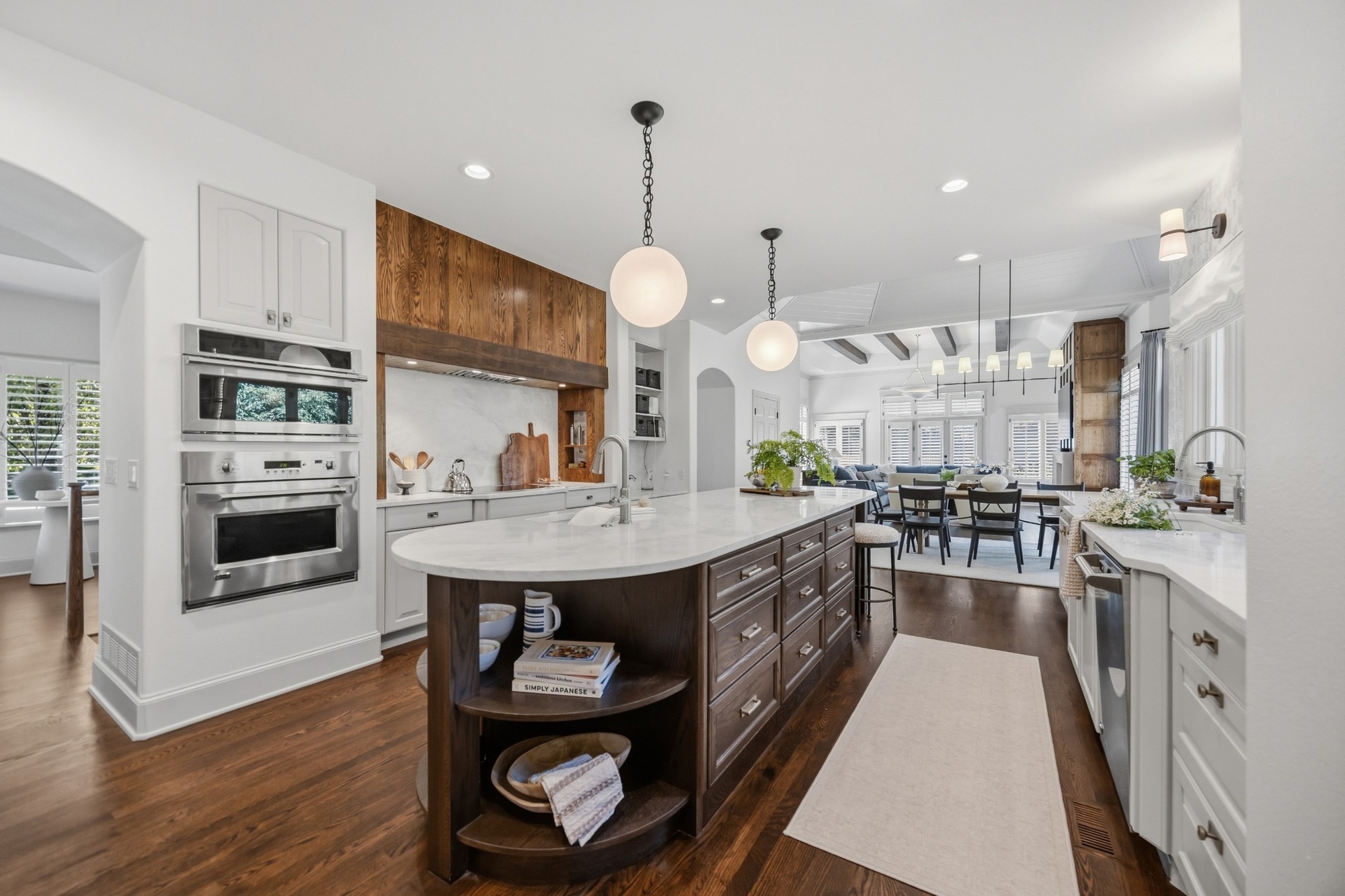 whole home remodel kitchen with large marble island wood cabinetry and pendant lights in greenwood village co