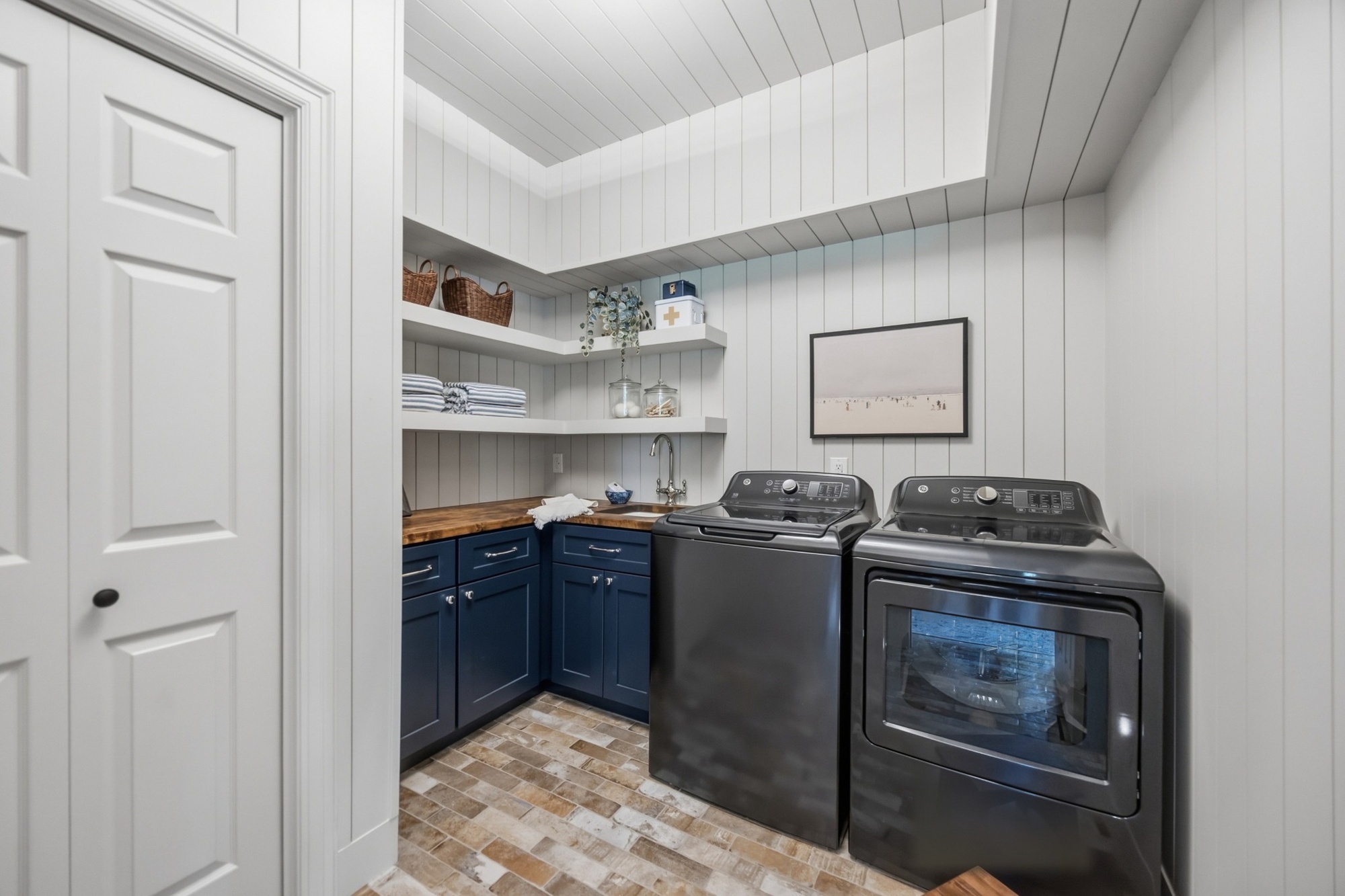 whole home remodel laundry room with navy cabinets utility sink and open shelving in greenwood village co
