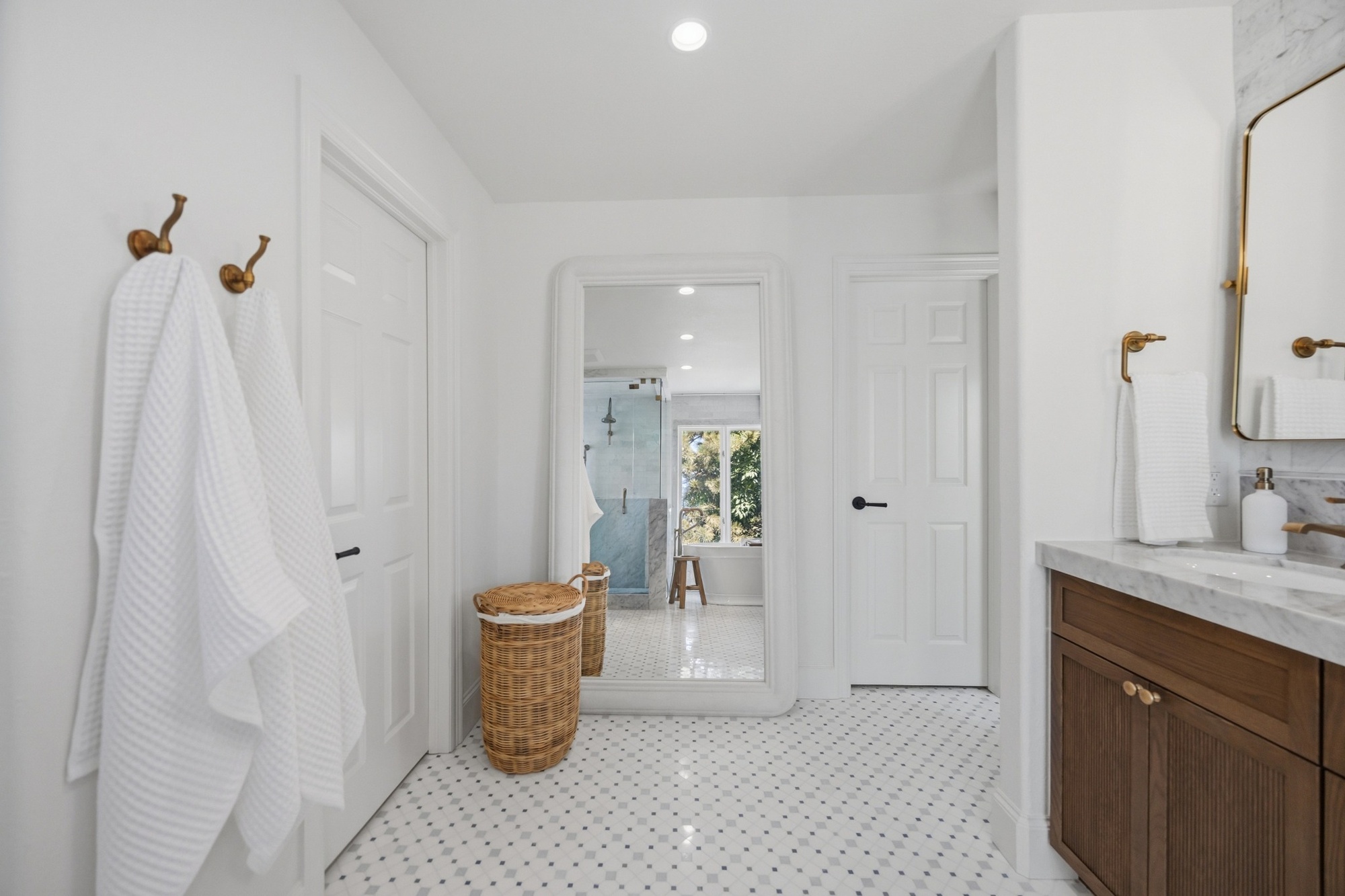 whole home remodel primary bathroom with wood vanity marble counters and patterned tile floor in greenwood village co