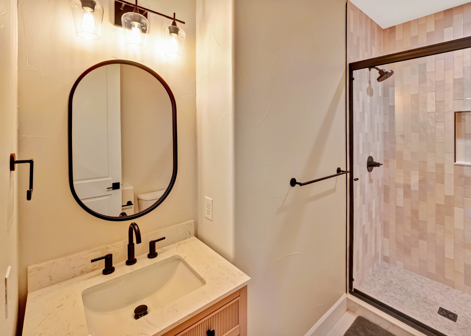 after castle pines whole home remodel bathroom with arched mirror black fixtures and walk in shower