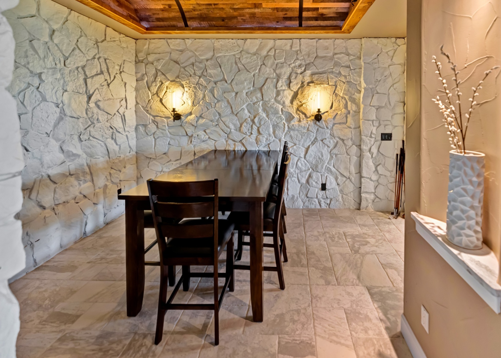 after castle pines whole home remodel stone dining room with wood ceiling and textured stone walls
