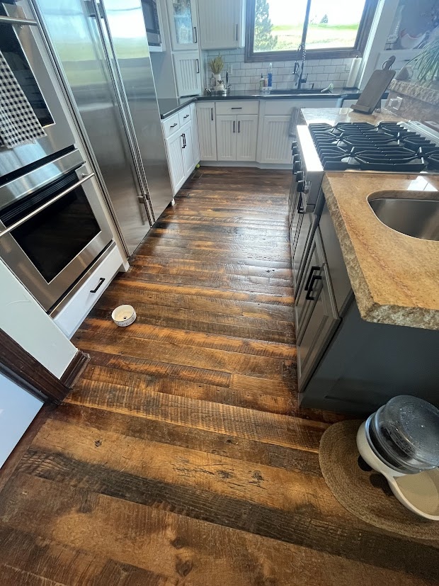 before castle pines whole home remodel kitchen with stainless steel appliances and dark hardwood floors