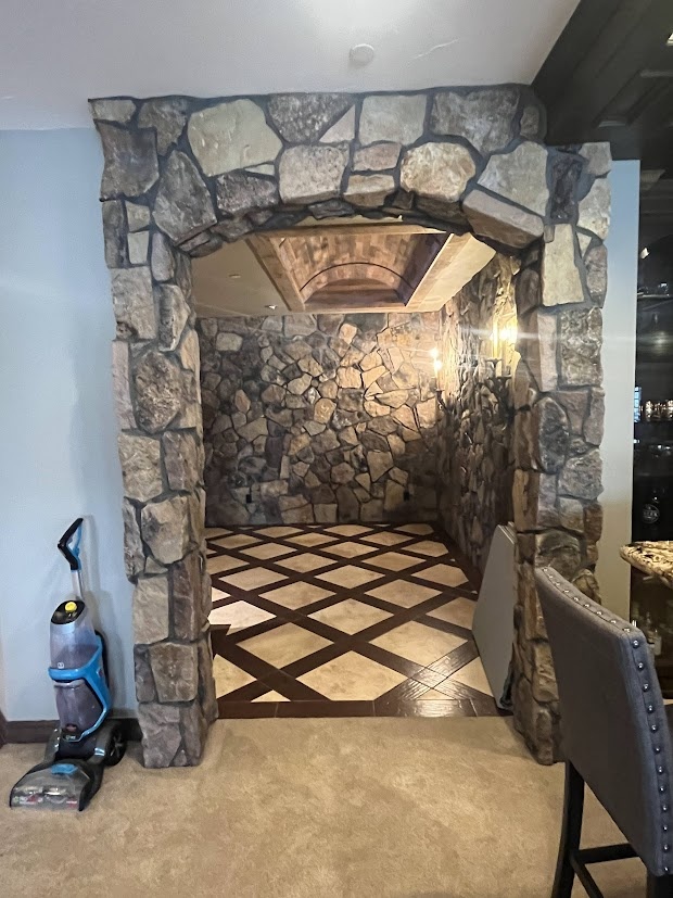 before castle pines whole home remodel stone wine room entrance with patterned tile floor