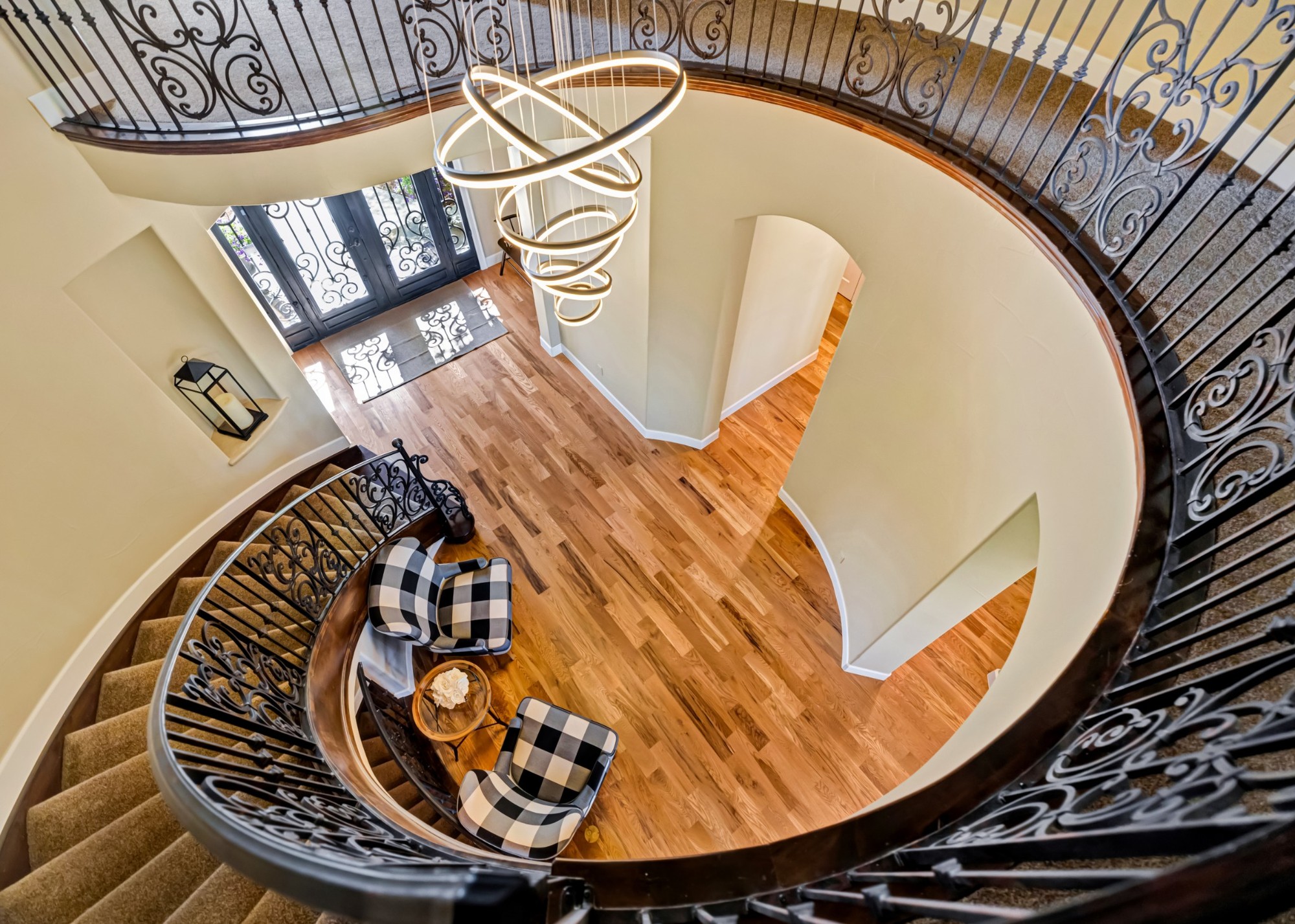 castle pines whole home remodel curved staircase overlooking elegant foyer and hardwood flooring
