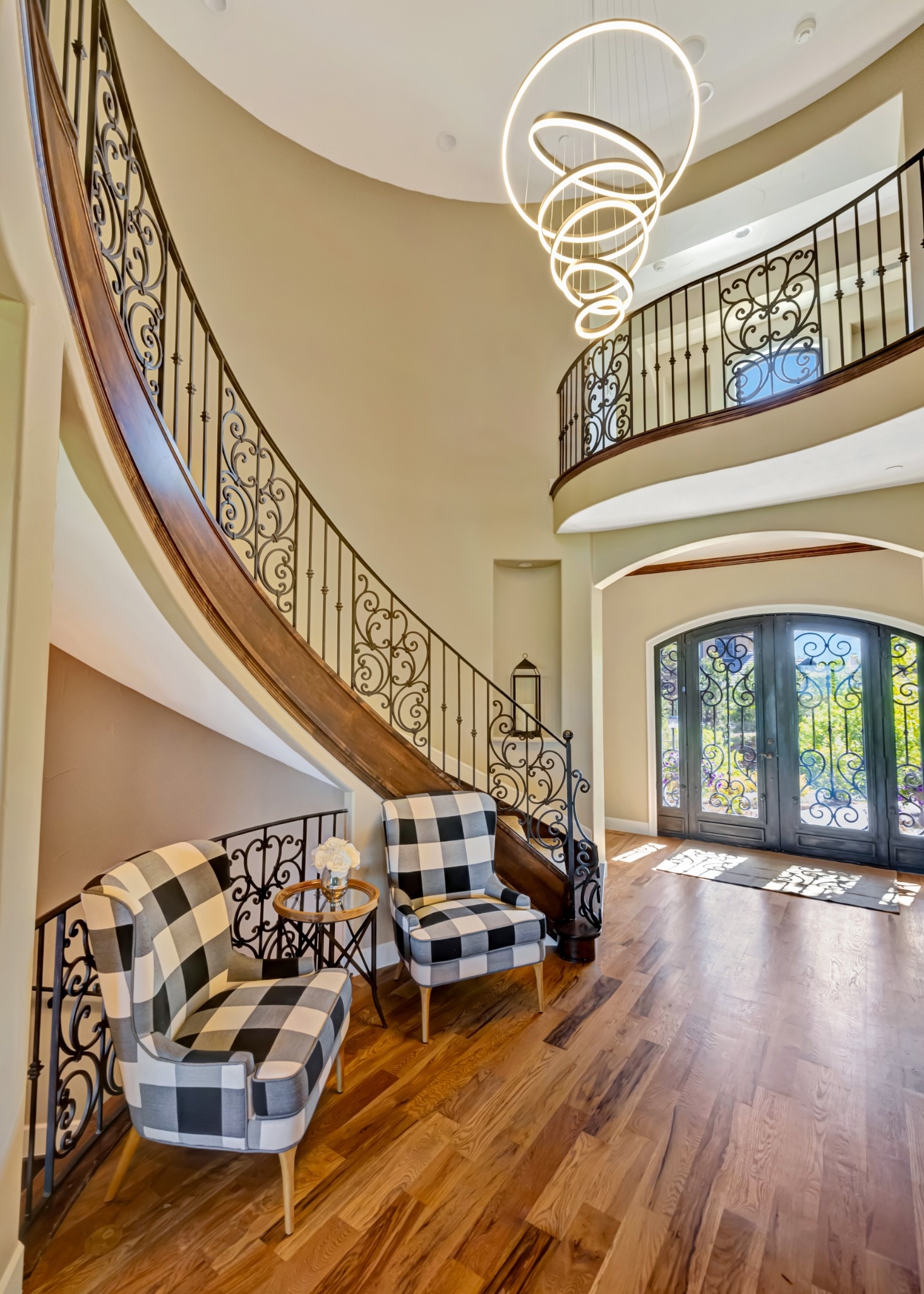 castle pines whole home remodel grand curved staircase with modern chandelier and hardwood floors