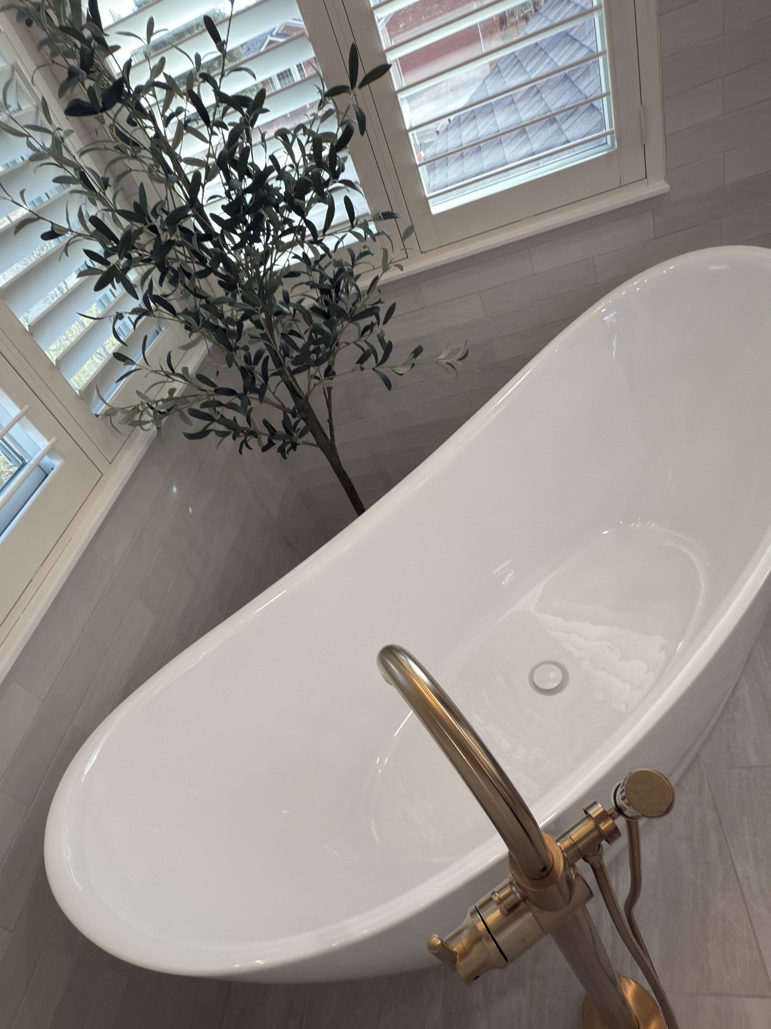 after littleton bathroom remodel close up of freestanding soaking tub and brass tub filler