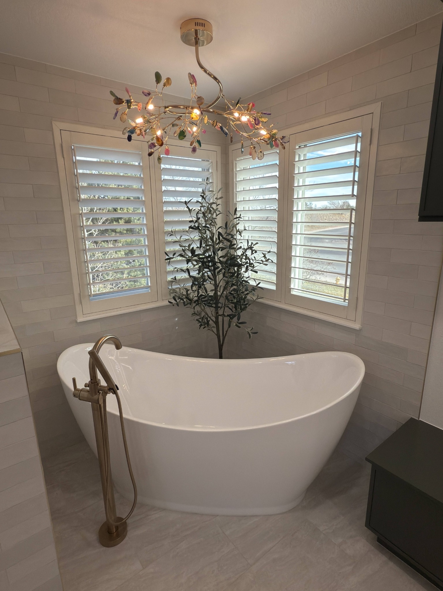 after littleton bathroom remodel freestanding tub with chandelier and gray tile walls