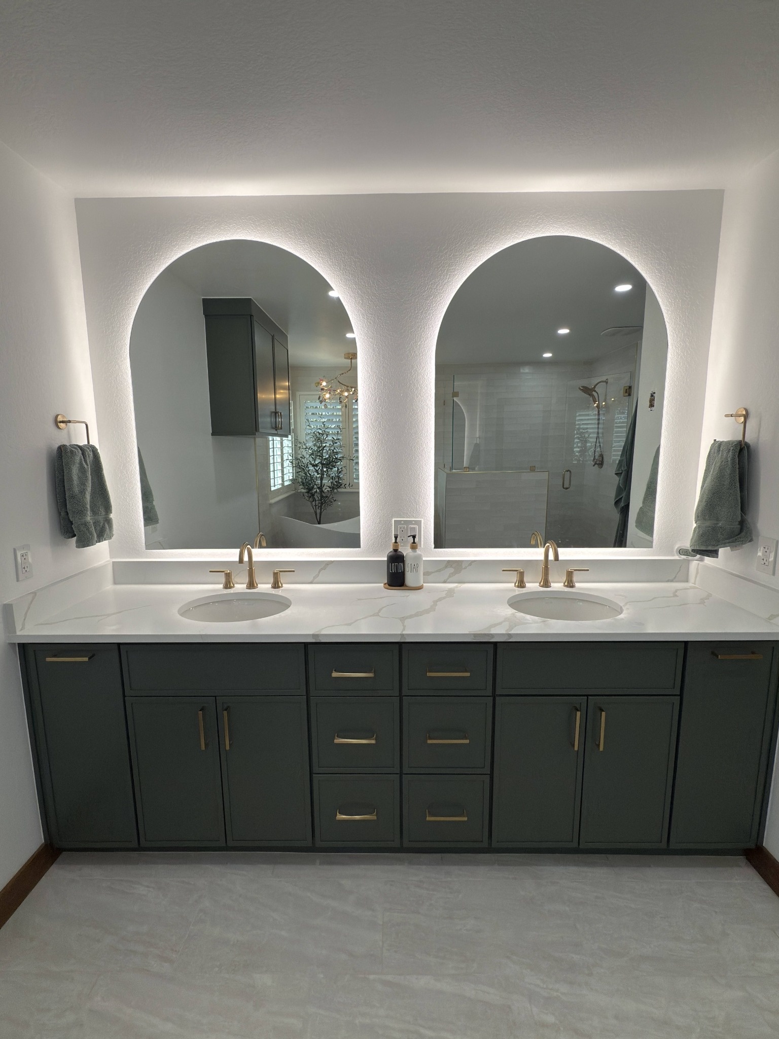 after littleton bathroom remodel straight on double vanity with backlit arched mirrors