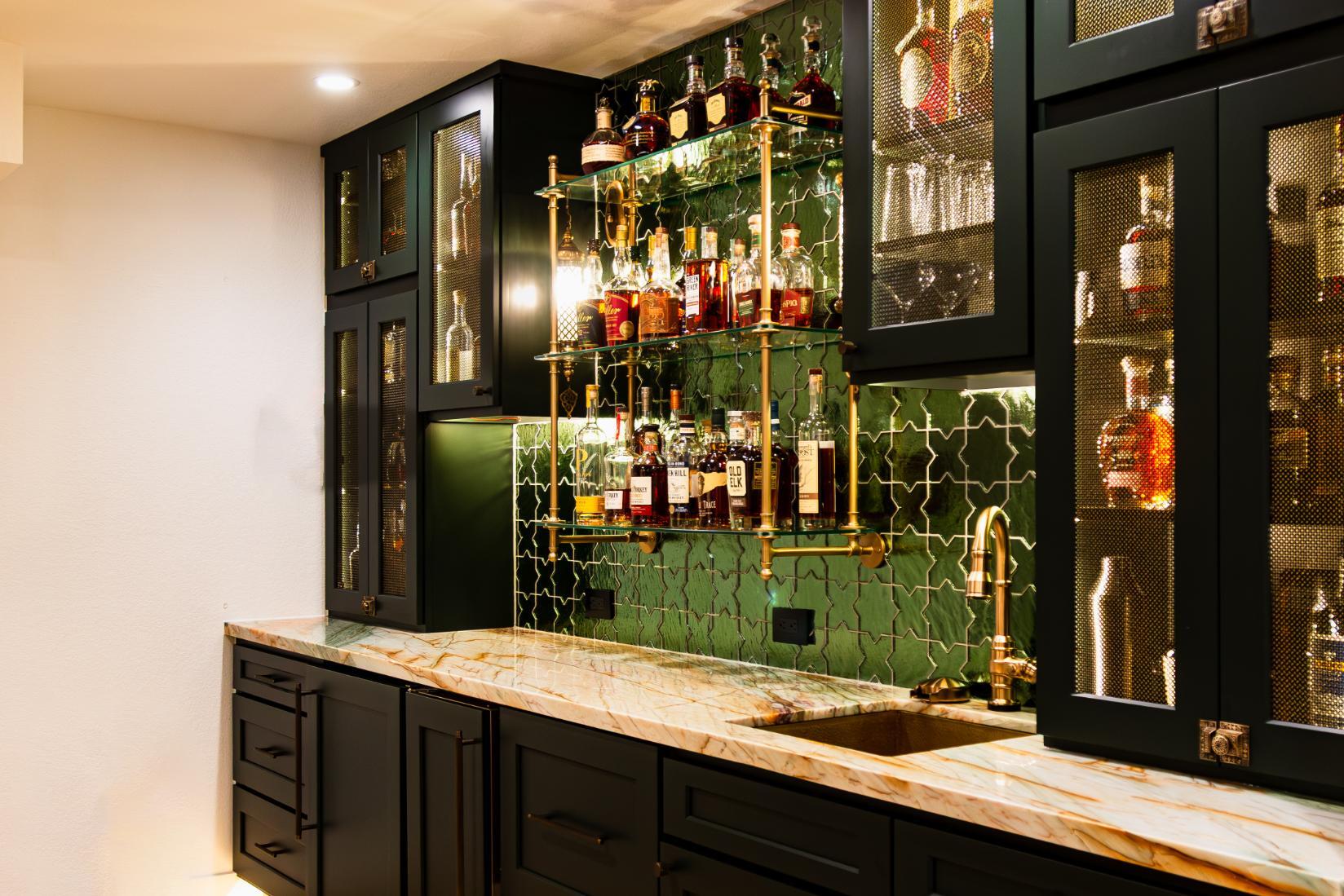 Corner view of black custom cabinetry and gold features in wet bar in basement remodel in Denver by Grimes Home Concepts