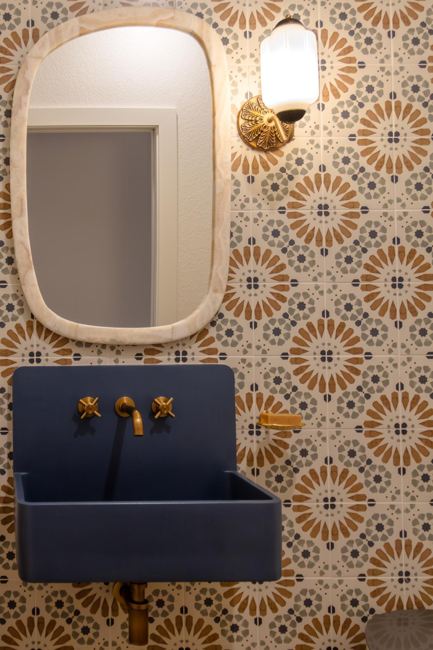 Gold and blue pattered wall paper with blue and gold sink in basement remodel in Denver by Grimes Home Concepts