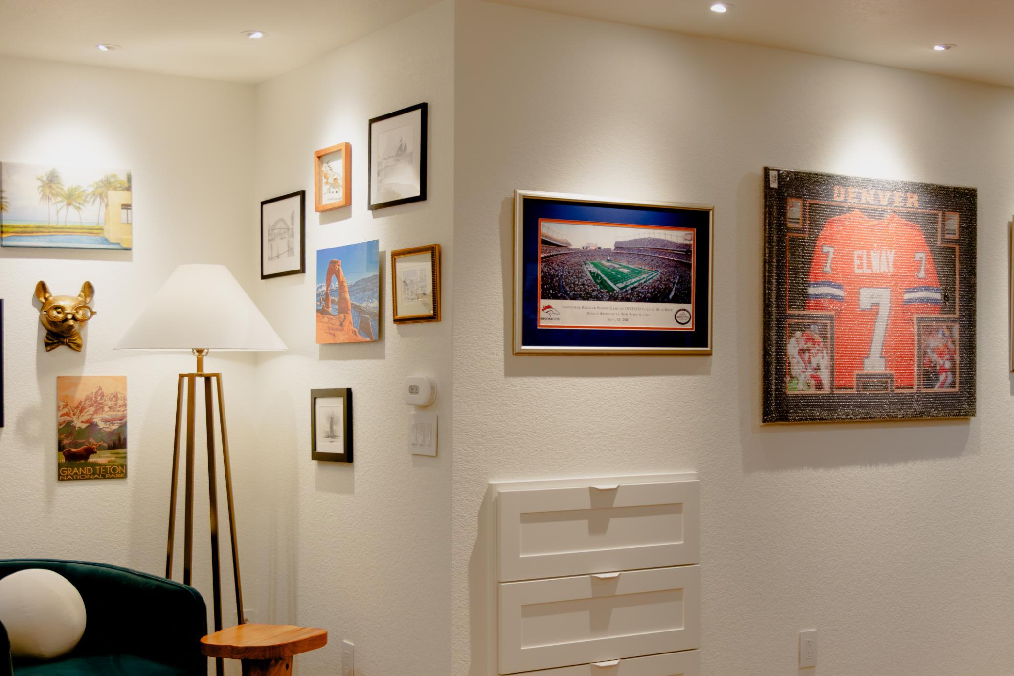 Basement remodel with stylish blue chair and wall decor in Denver by Grimes Home Concepts