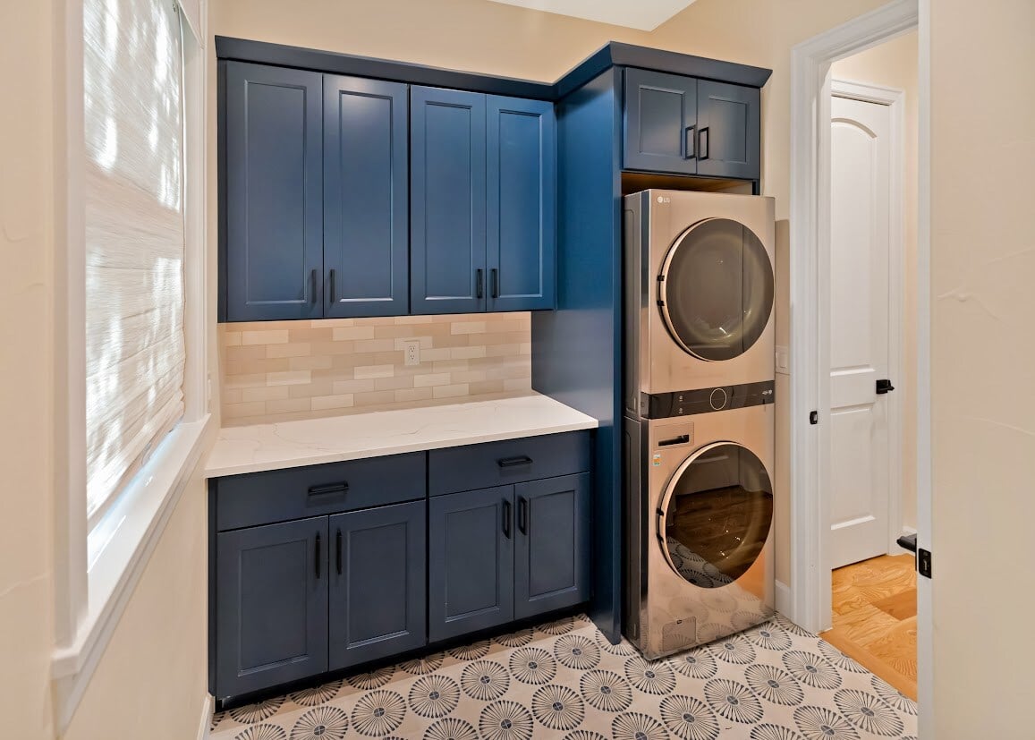 laundry room with blue and white tile and rich blue cabinetry in denver, colorado